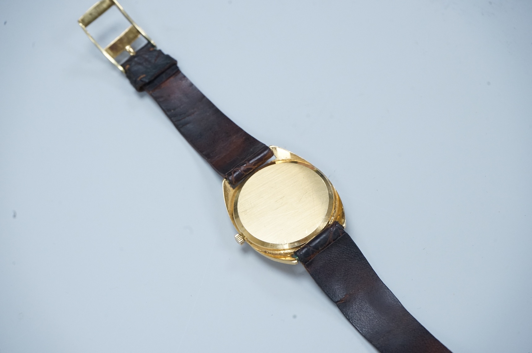 A gentleman's early 1970's 18ct gold Omega manual wind wrist watch, with baton numerals, case diameter 35mm, movement c.601, on a leather strap with gold plated buckle, no box or papers.